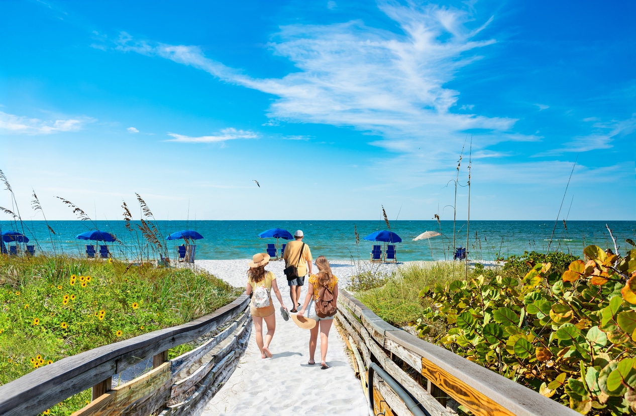 Family on summer vacation trip in Florida. People walking on pathway to the beach. Friends exploring island along the Gulf Coast. Caladesi Island State Park, USA, Florida.